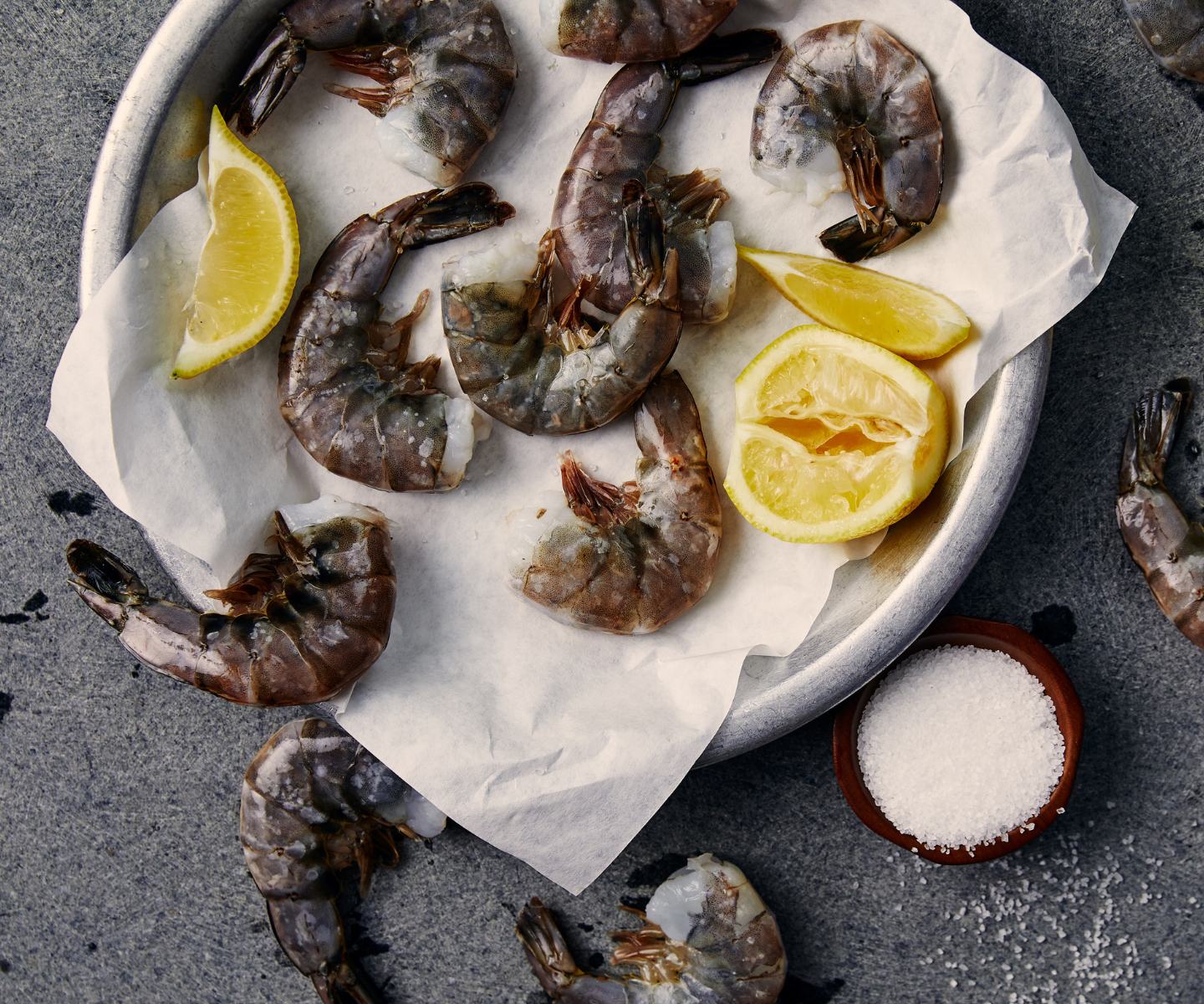Headless shrimp on a platter with lemon and sea salt