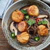 Atlantic Sea Scallops served in broth with noodles and mushrooms, topped with peppers