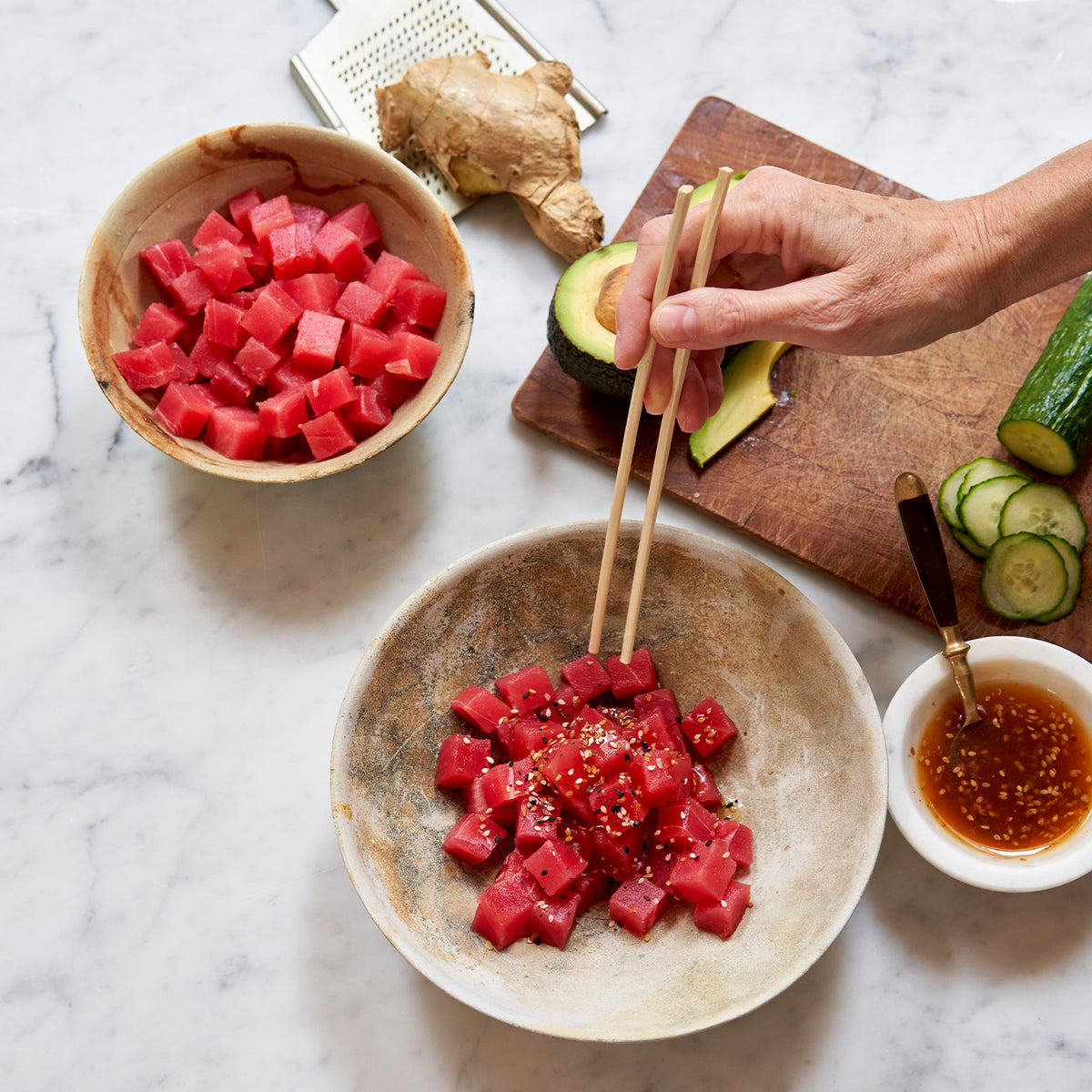 Chopsticks reaching for cubed ahi tuna 