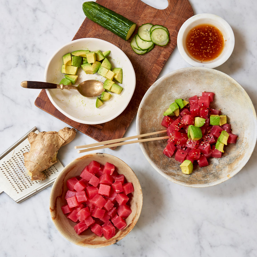 Avocado, cucumber, ginger, and Ahi tuna spread out on a table. 