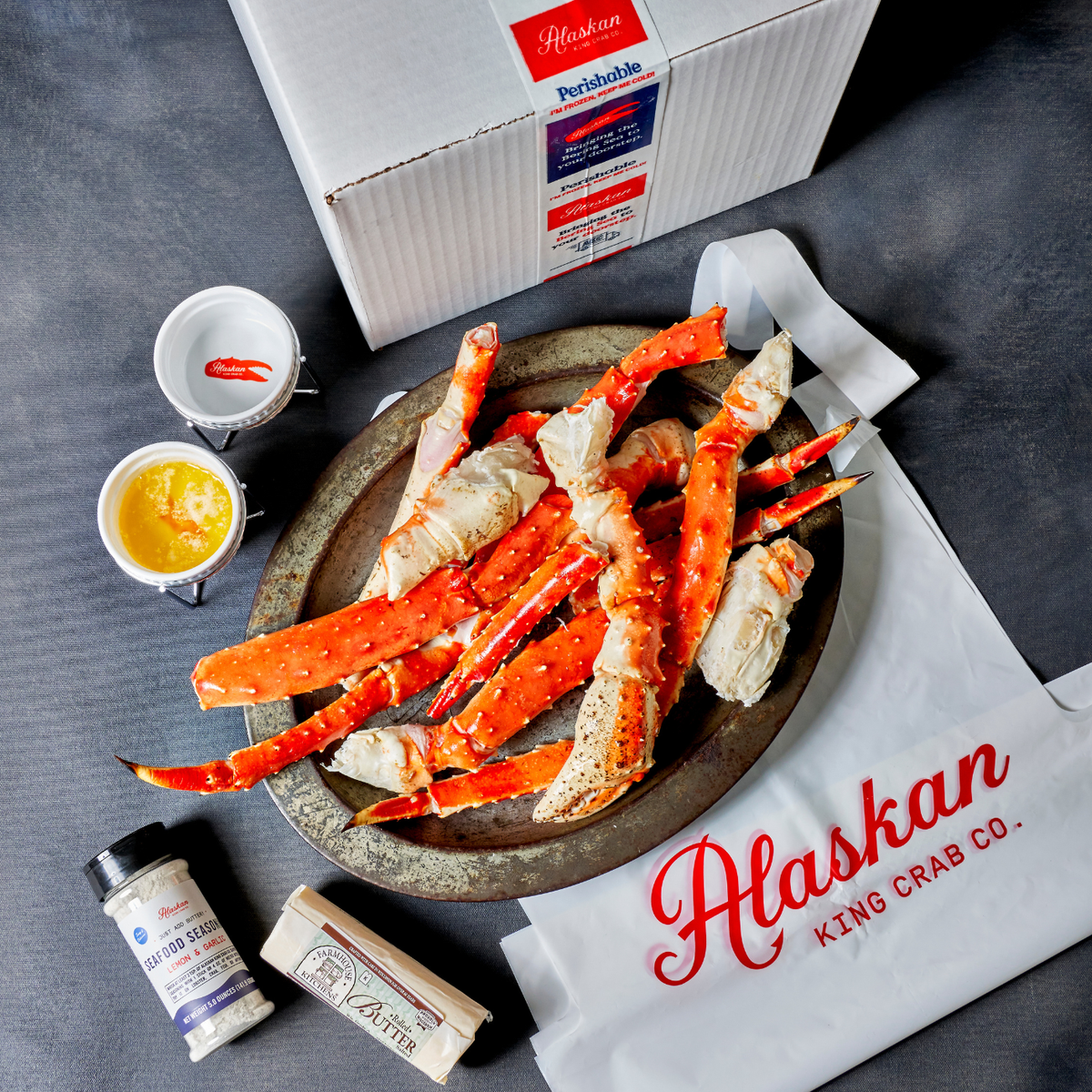 King Crab Legs on plate with Alaskan king Crab Co. Bibs