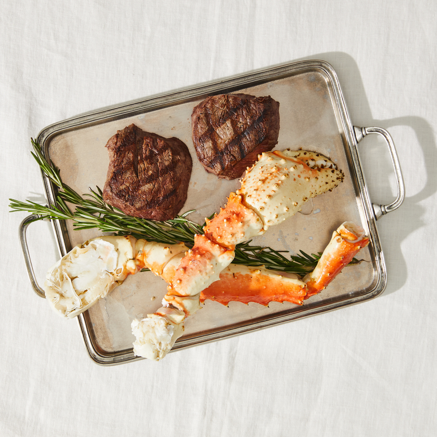 Tray with grilled steak and king crab leg on a white background