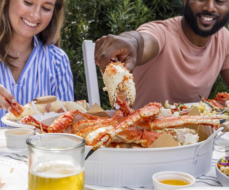 Man and woman enjoying a crab feast.