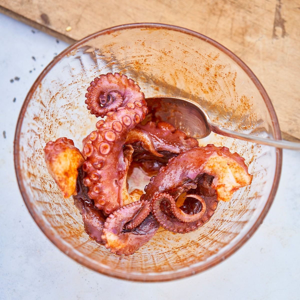 Octopus being seasoned in a bowl 
