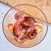 Octopus being seasoned in a bowl 